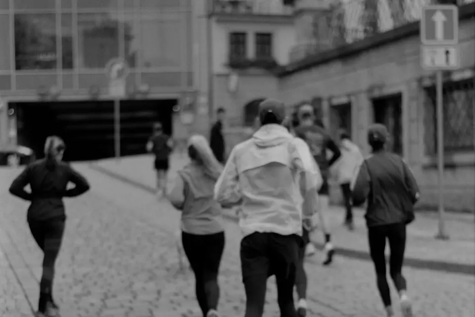 A group of runners walking together along a city street.